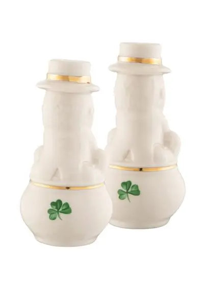 Two ceramic salt and pepper shakers designed to look like leprechauns wearing white hats and golden belts isolated on a white background.